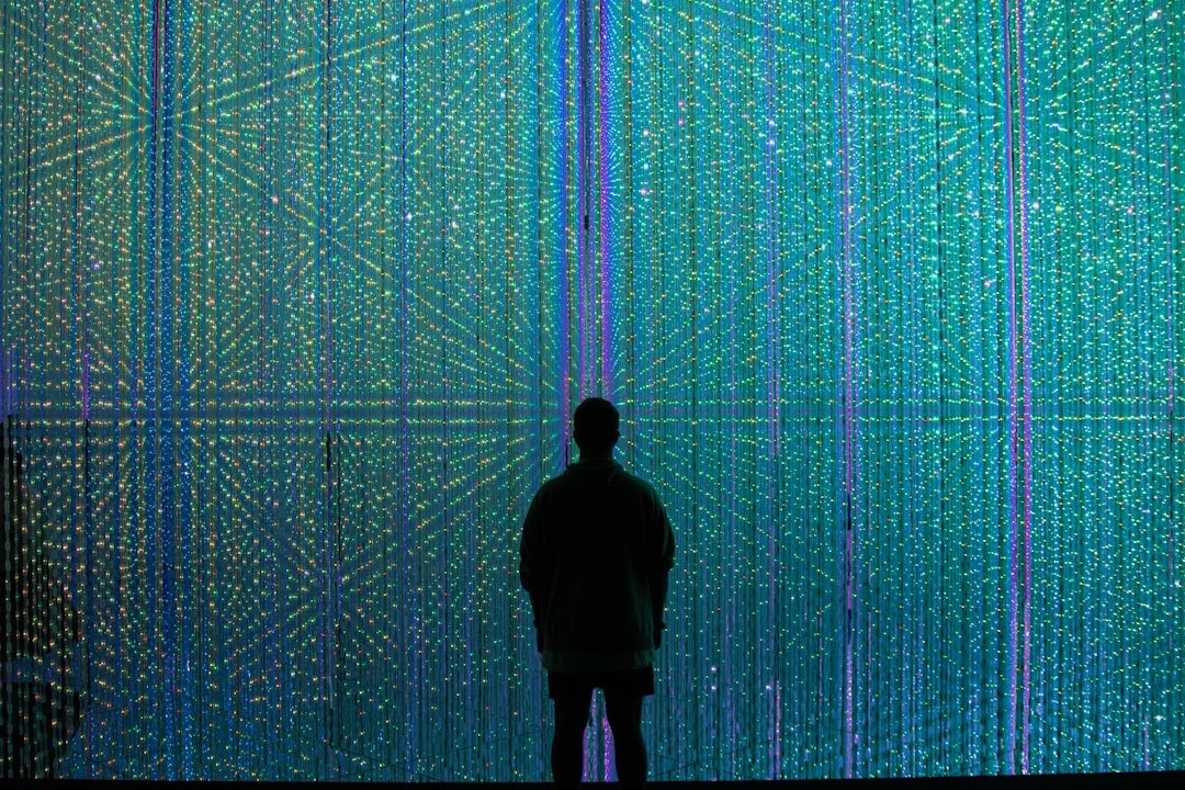 Person in a modern setting looks thoughtfully at a glowing, holographic map, symbolizing the navigation of the new digital...