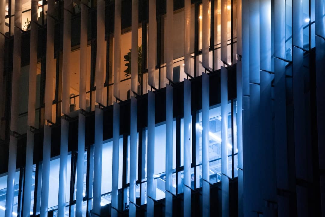 Detailed, glowing blue digital blueprint of a complex building on a dark background, representing the architecture of an A...