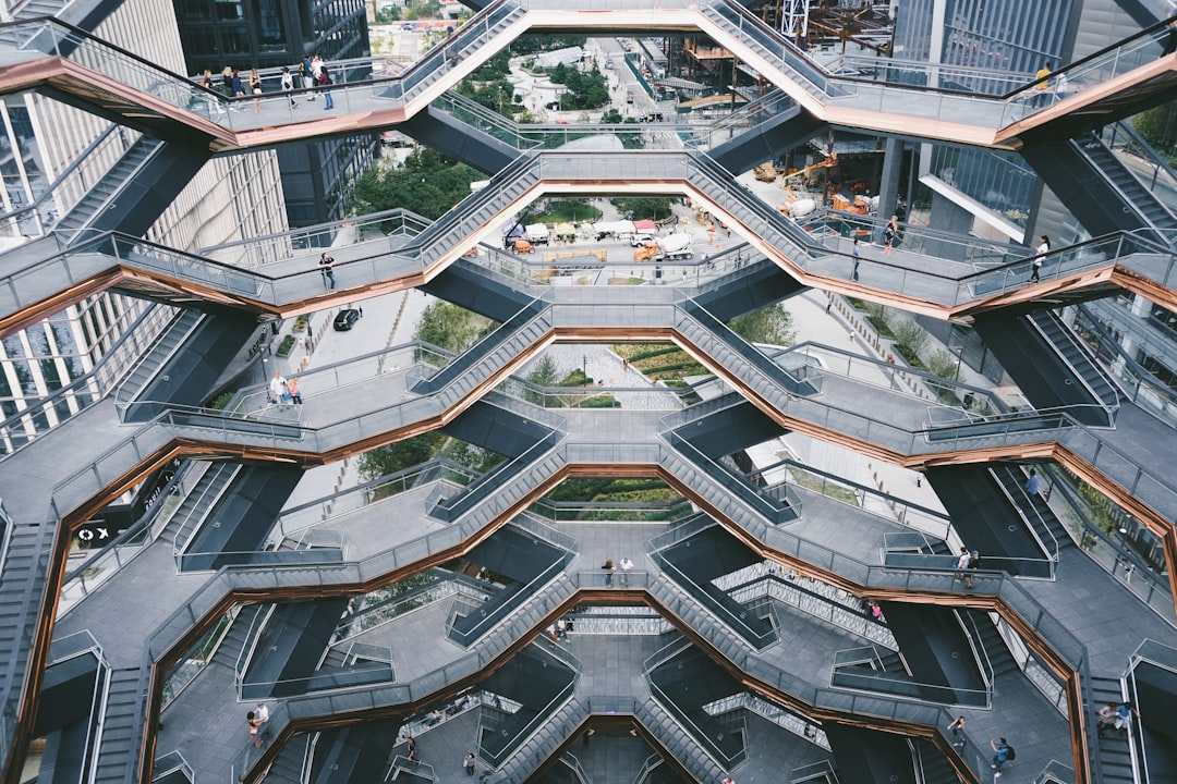 Two professionals in a bright, modern office looking over a detailed architectural model of a city, representing strategic planning for multi-location real estate.