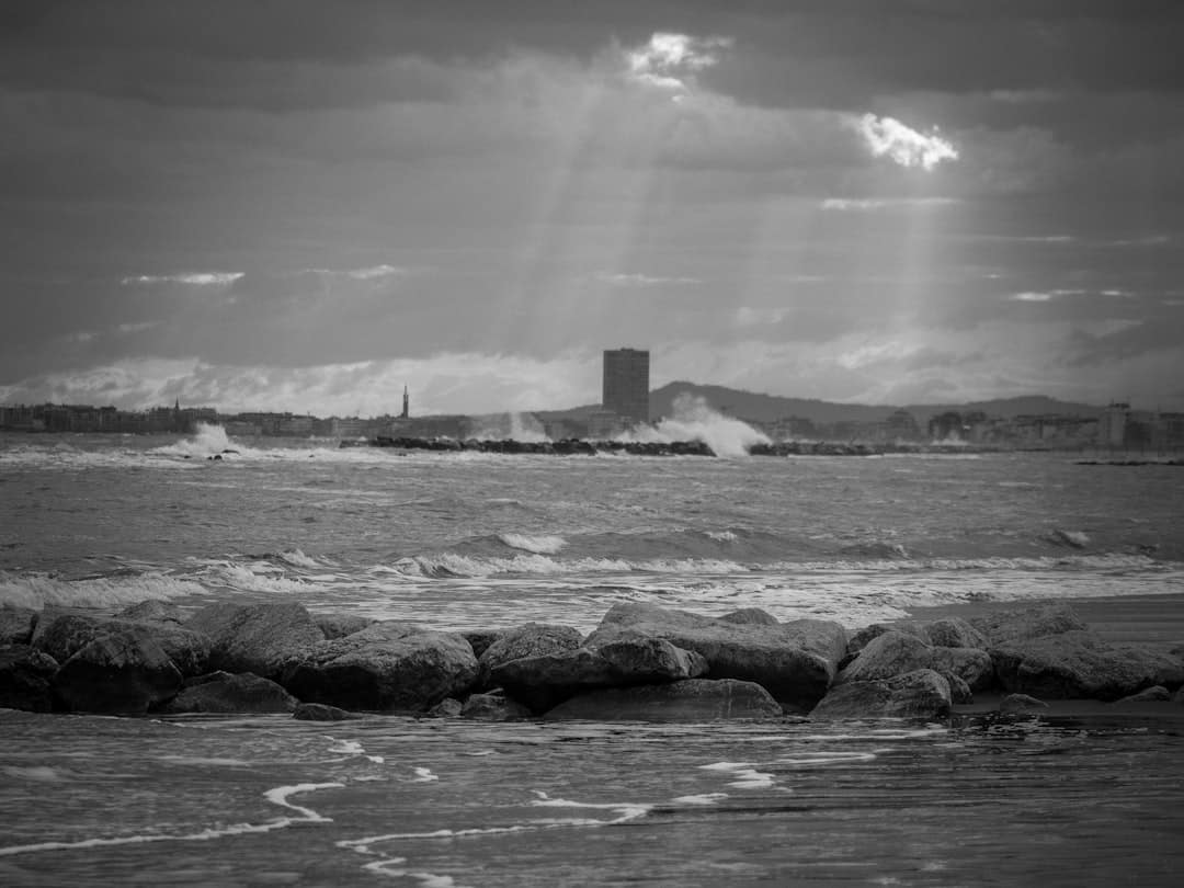 A strong lighthouse stands firm on a rocky coast against stormy waves, symbolizing a defensible SEO moat in a shifting digital landscape.