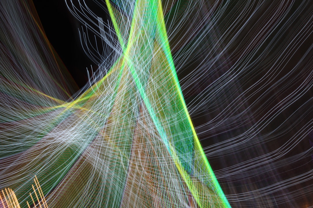 Modern, abstract image showing multiple glowing lines from different directions converging into a single, bright, straight...