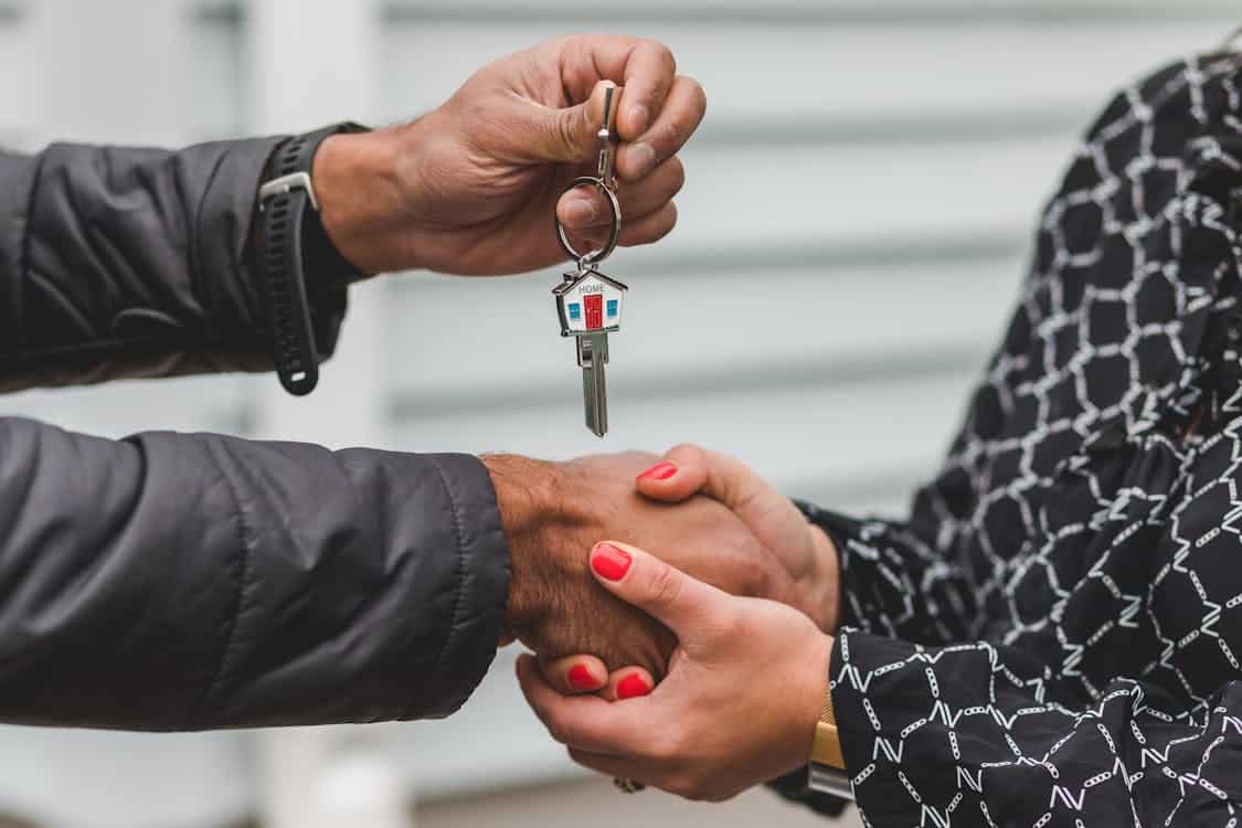 Two business professionals shaking hands to finalize a deal in a bright, modern office, representing the successful conversion from a lead to a signed contract.