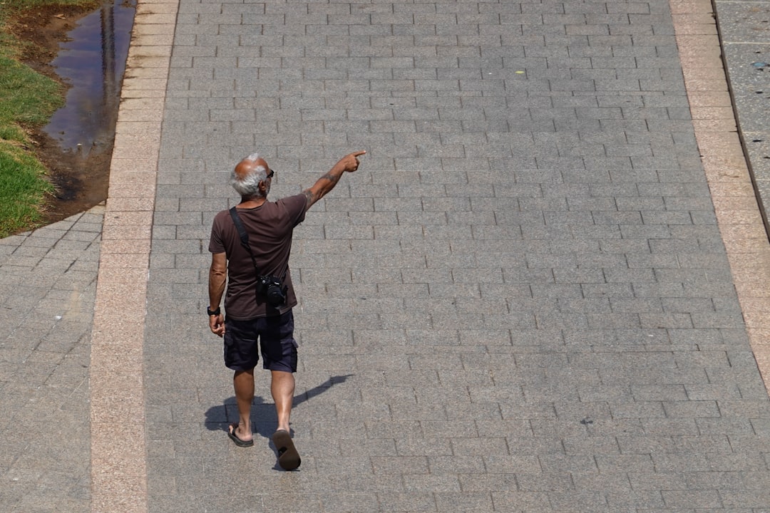 An architect or city planner in a modern office pointing to a specific area on a detailed physical model of a city neighborhood, symbolizing hyper-local data and real estate expertise.