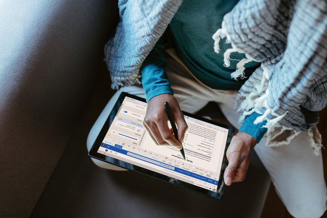 Close-up of a person's hand using a stylus to draw a glowing boundary around a neighborhood on a digital map displayed on ...