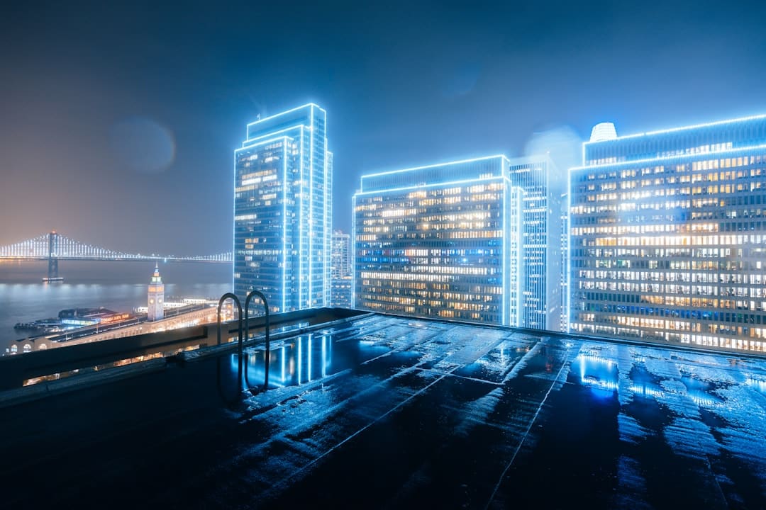 An aerial view of a city at night with glowing digital lines connecting various points, symbolizing real estate data syndication and network partnerships.