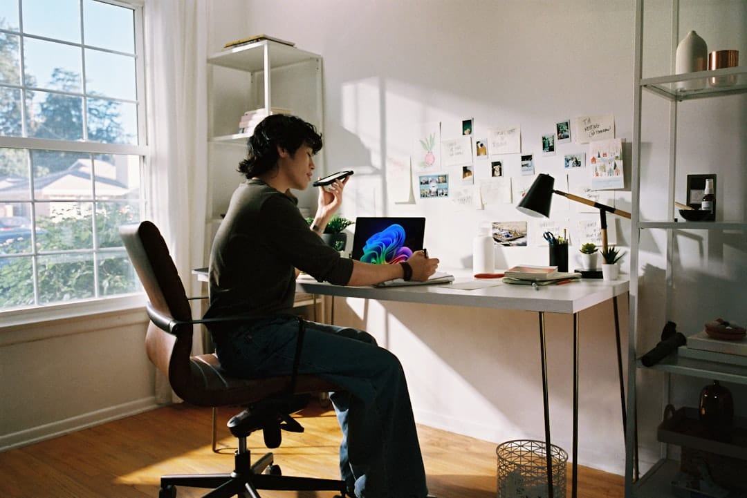 A professional person wearing a headset and looking at a computer screen in a bright, modern office, representing the source of voice of the customer data.