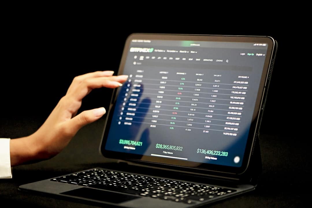 A professional's hand touching a large, glowing futuristic screen displaying complex data points and analytics, representing AI-driven real estate insights.