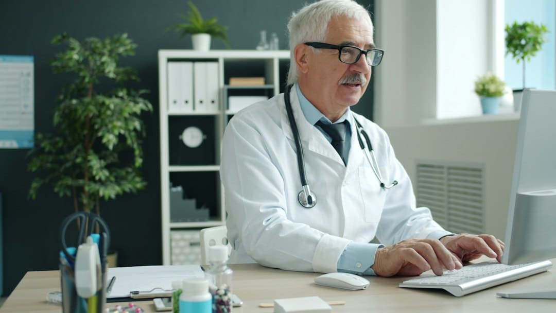 A doctor in a bright, modern clinic reviews patient information on a digital tablet, showcasing the intersection of advanced technology and healthcare services.