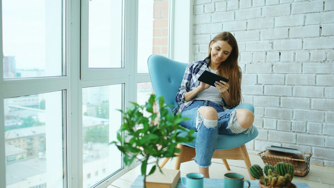 A real estate professional in a bright, modern home, focused on a tablet screen, meticulously organizing sold listing data with precision and authority.